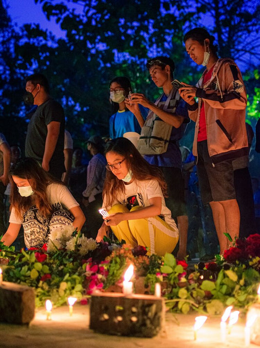 People gathered around lit candles, creating a moment of reflection often honored in a eulogy.