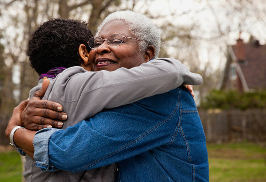 Elderly woman embracing a younger person—capturing the warmth and support often shared during a celebration of life.