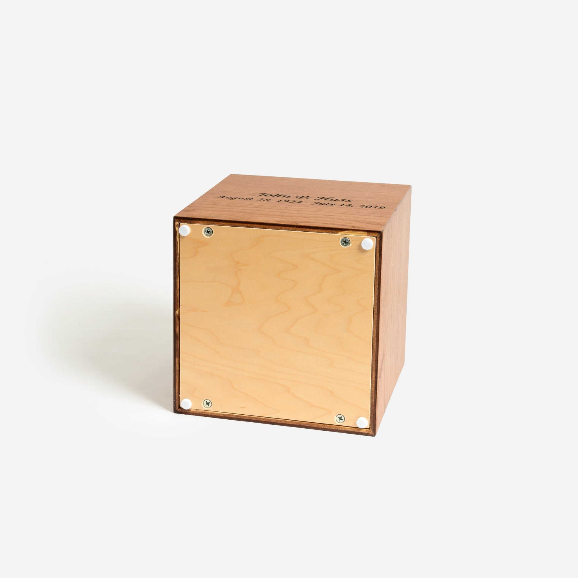 Underside of cherry cremation urn showing secure screw-fastened panel