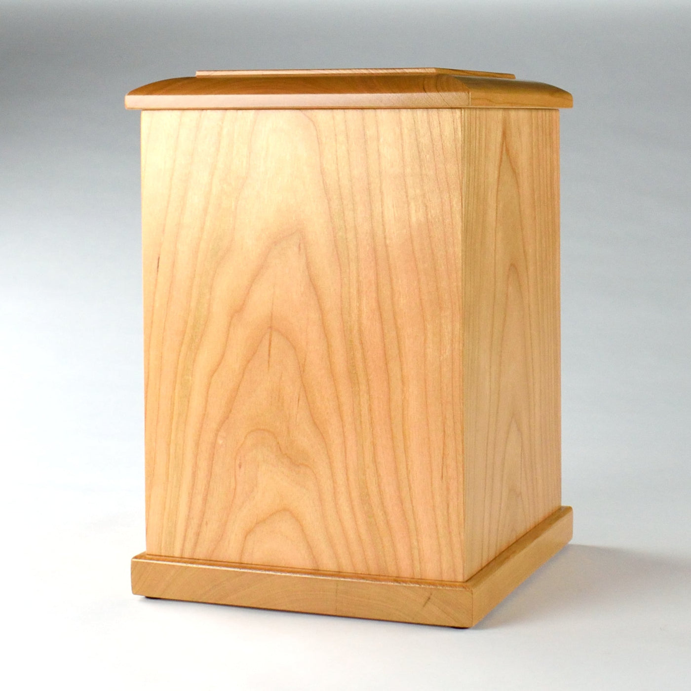 Angled front image of tall cherry wood urn showing warm finish and detailed craftsmanship