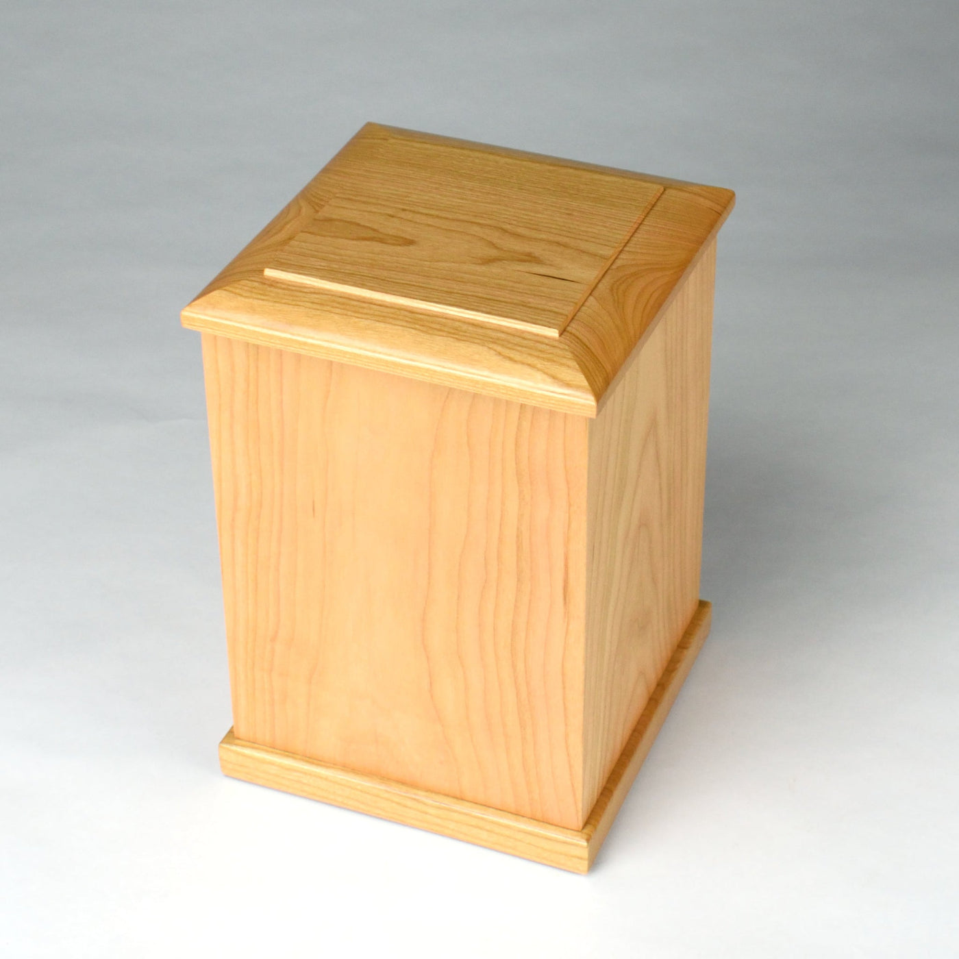 Top-down view of upright cherry cremation urn showing smooth lacquered surface and wood grain